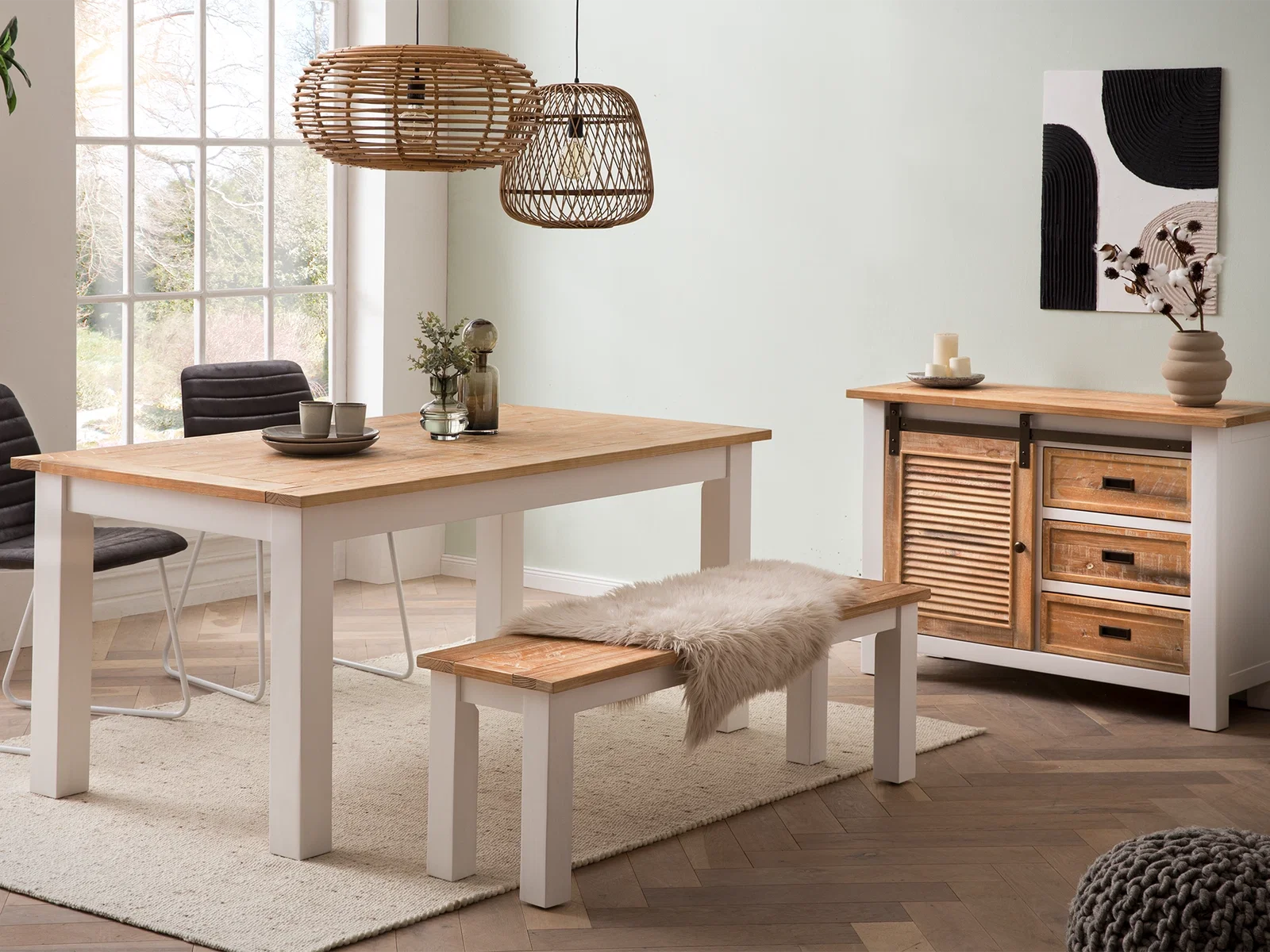 Sommerliches Esszimmer mit Holztisch, Bank, Korbleuchten und Sideboard als ruhige Basis für lange Abende zuhause