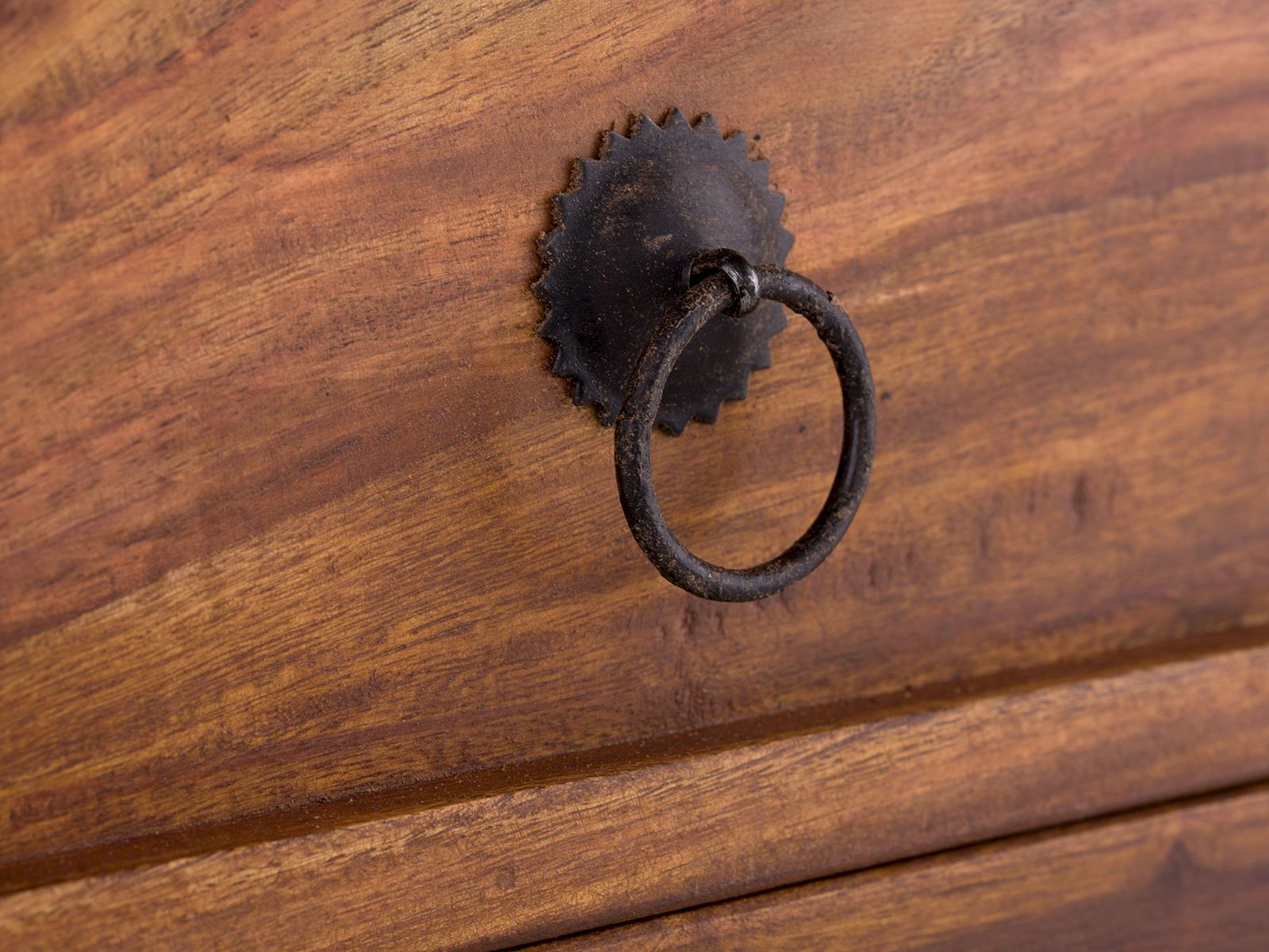 Detailbild Sideboard Merlino Akazie: Lackierte Akazie-Oberfläche mit rustikalem, schwarz-grauem Metallringgriff an der Fronttür. Detailbild Sideboard Merlino Akazie: Lackierte Akazie-Oberfläche mit rustikalem, schwarz-grauem Metallringgriff an der Fronttür.