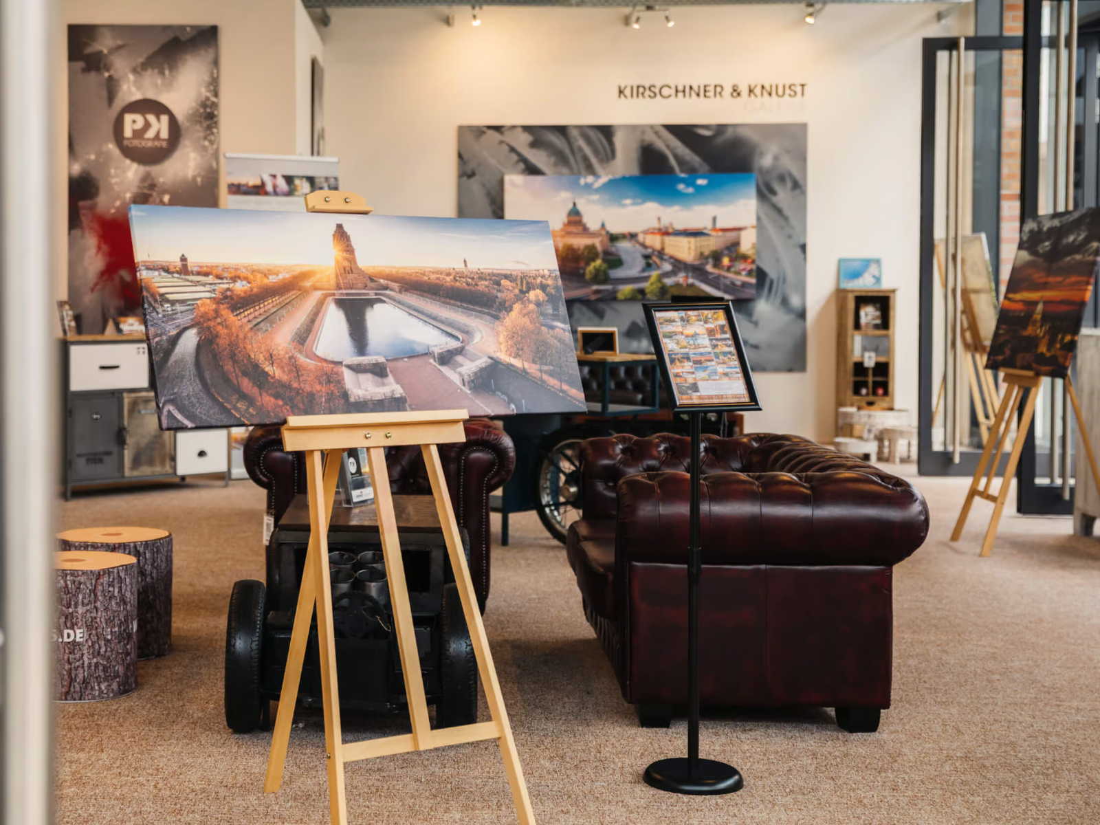 Blick in die Fotogalerie von Philipp Kirschner in Brehna mit Chesterfield-Ledersofas von Woodkings und großformatigen Fotografien auf Staffeleien