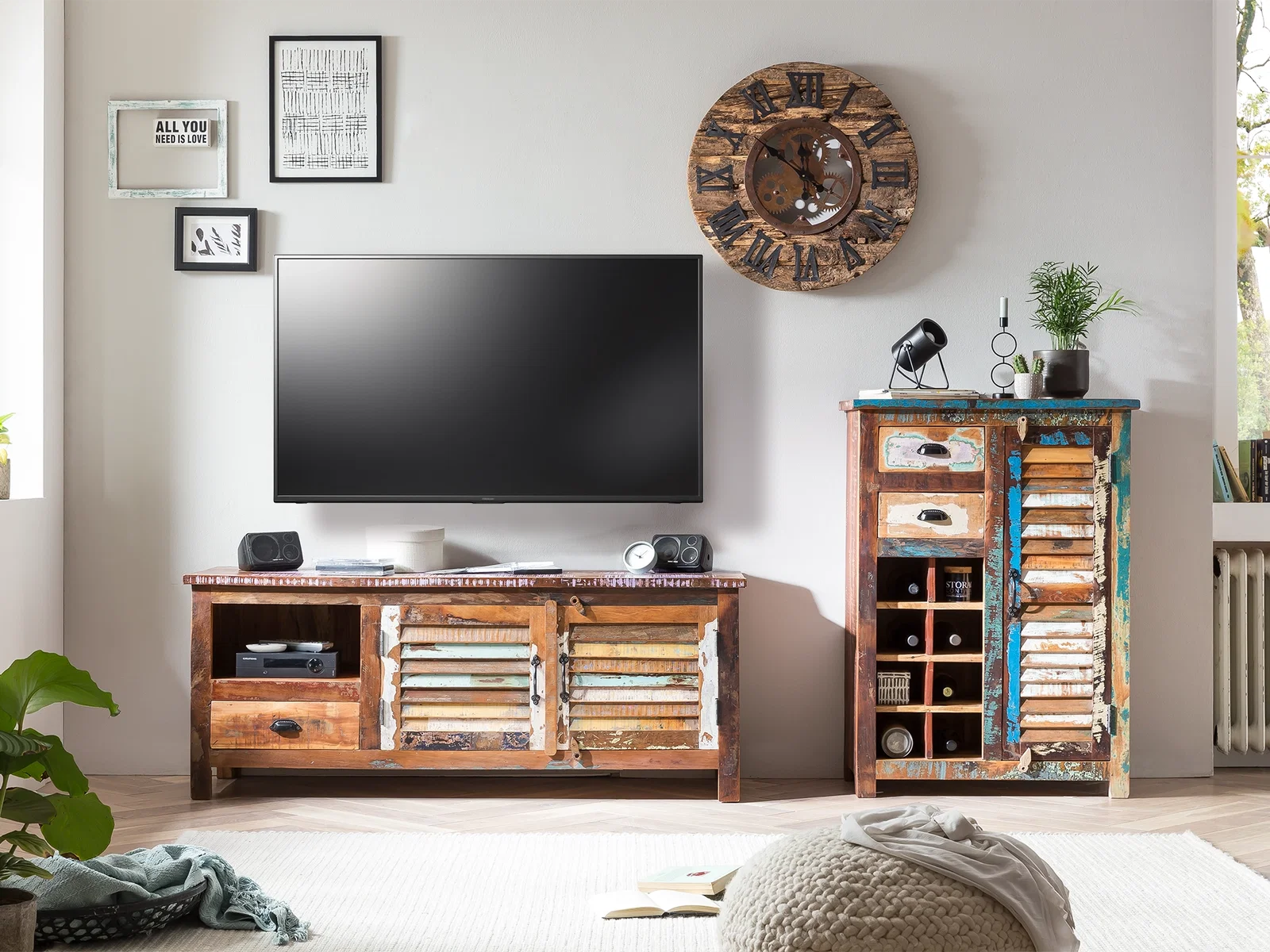 Highboard Wakefield aus Altholz mit Schubladen und offenen Fächern neben einer TV-Bank und einem Fernseher im hellen Wohnzimmer