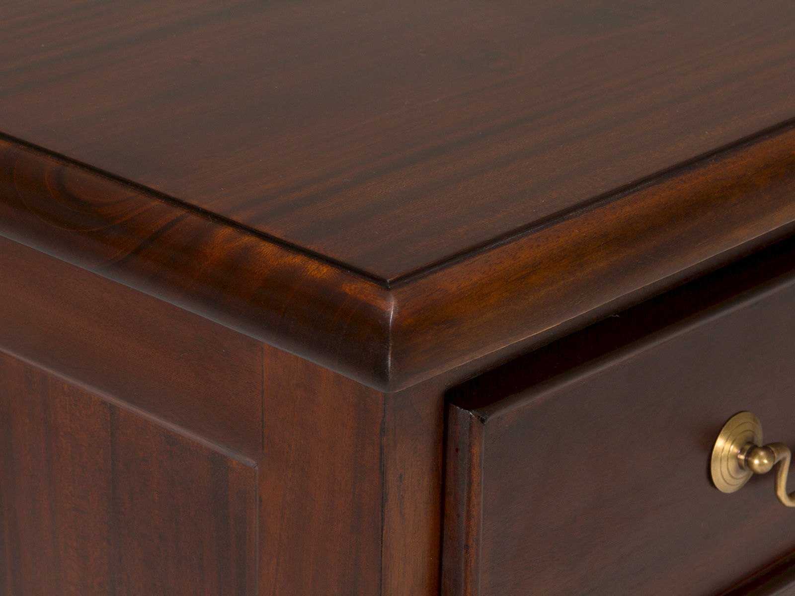 Detailansicht: Lackierte Mahagoniholz-Oberfläche mit abgerundeter Kante des Sideboard Cambridge I (braun) und Messinggriff.