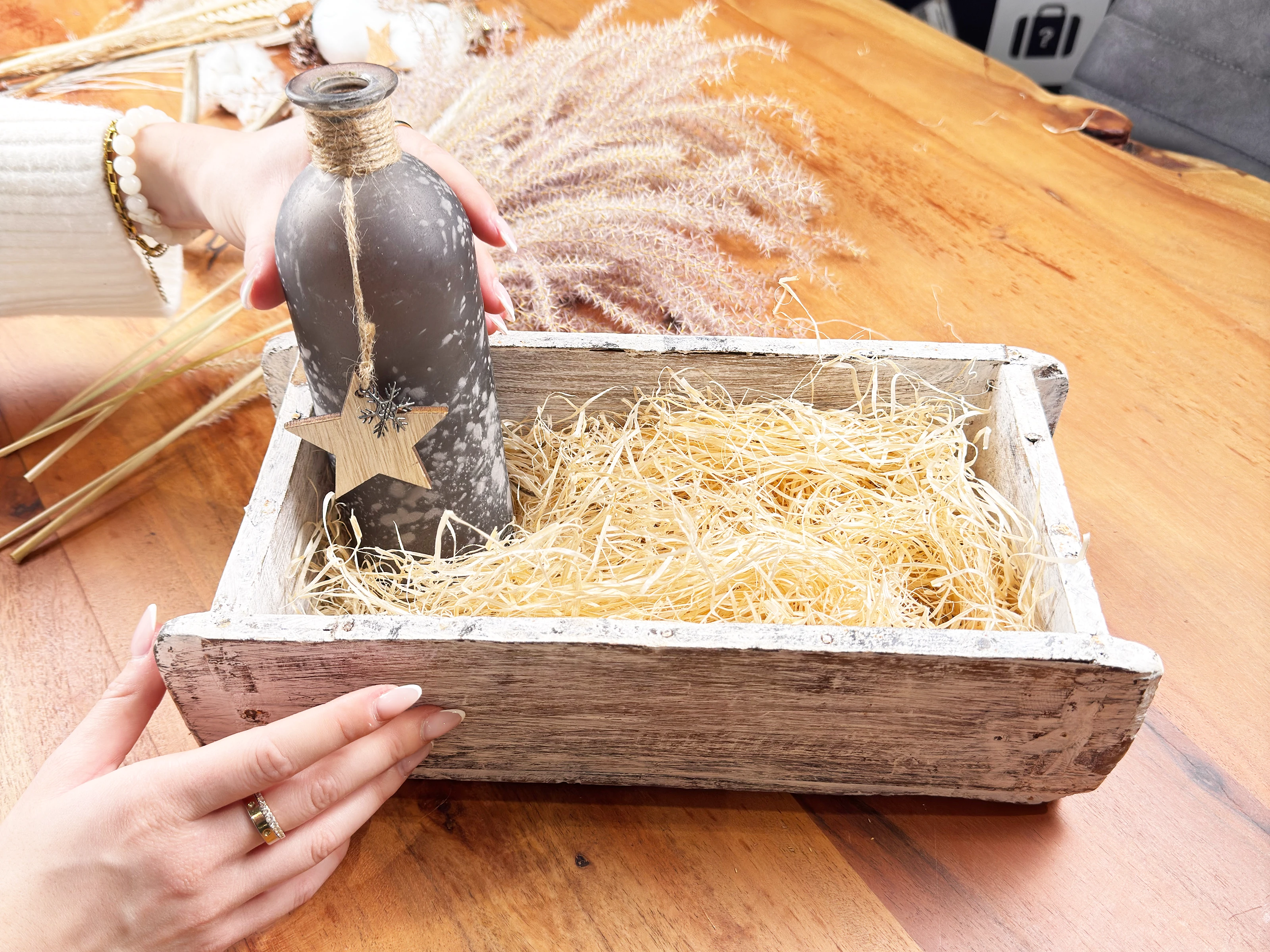 Boho Sessel Luisa aus Rattan mit hellem Kissen in naturnahem Wohnambiente, warme Erdtöne und entspannte Atmosphäre