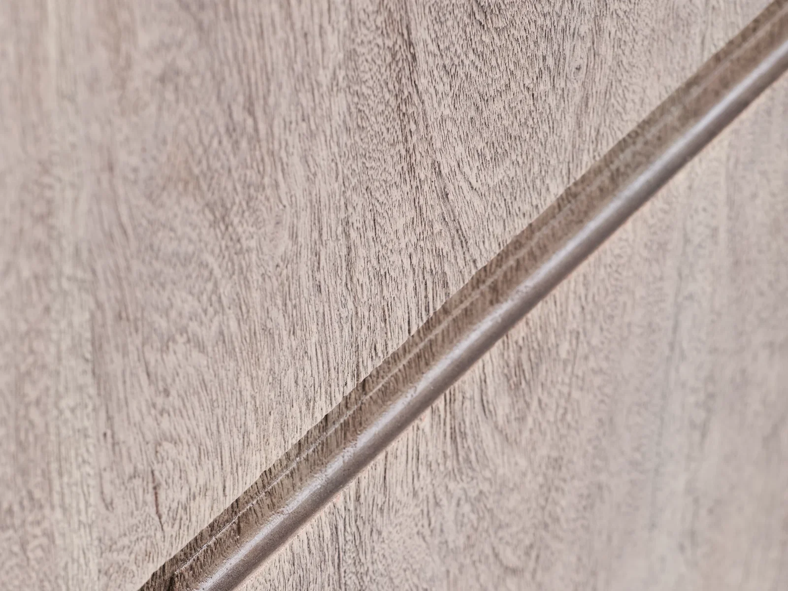 Detailaufnahme der grauen Akazienholz-Oberfläche des Lowboards Kala mit diagonalem Griffprofil, Freisteller für Produktdetailansicht