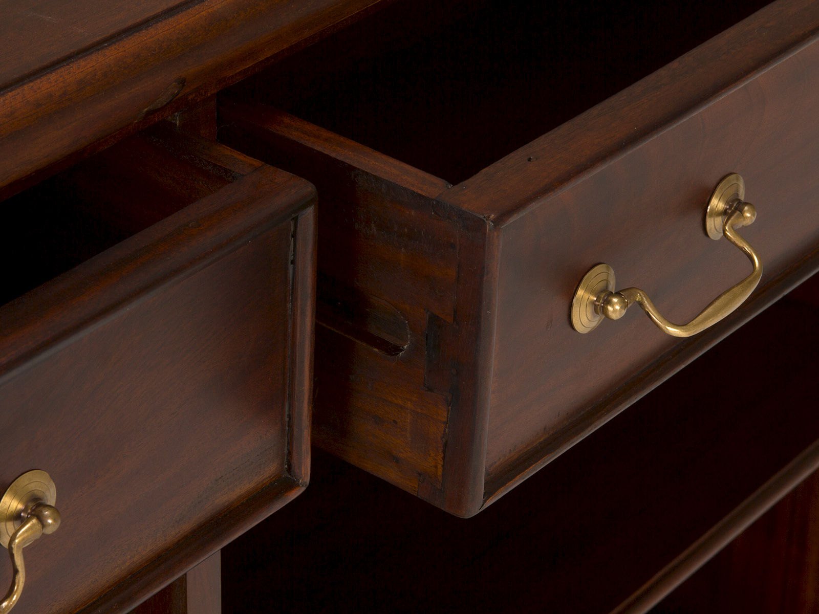 Sideboard Cambridge I Detailbild: offene Mahagoni-Schubladen mit Messinggriffen in 45°-Ansicht, lackierte Holzoberfläche braun