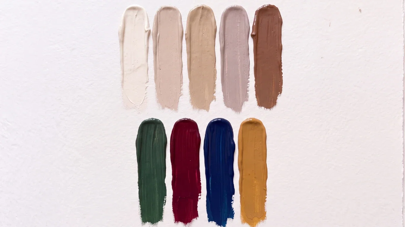 Farbpalette mit Creme, Beige, Sand, warmem Grau, Braun, Dunkelgrün, Bordeaux, Navy und Ocker