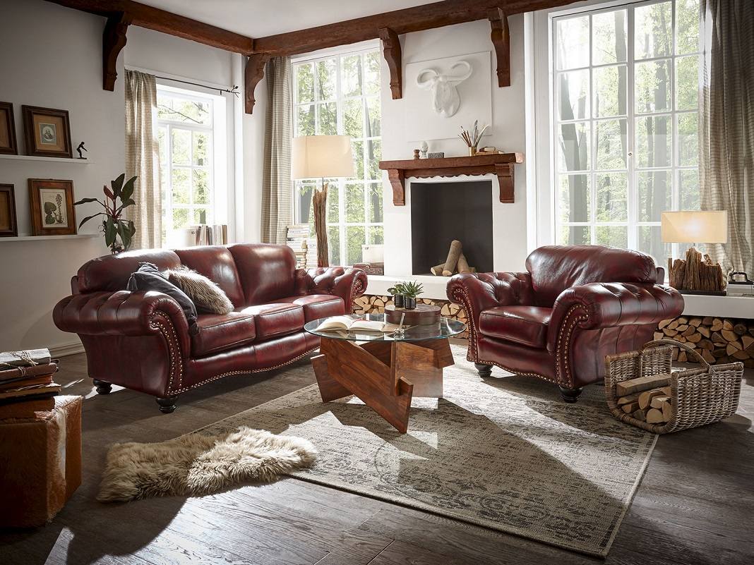Ledergarnitur 3‑1 aus braunem Leder im modernen Wohnzimmer: Sofa, Sessel, helles Parkett, Kissen, warmes gemütliches Ambiente