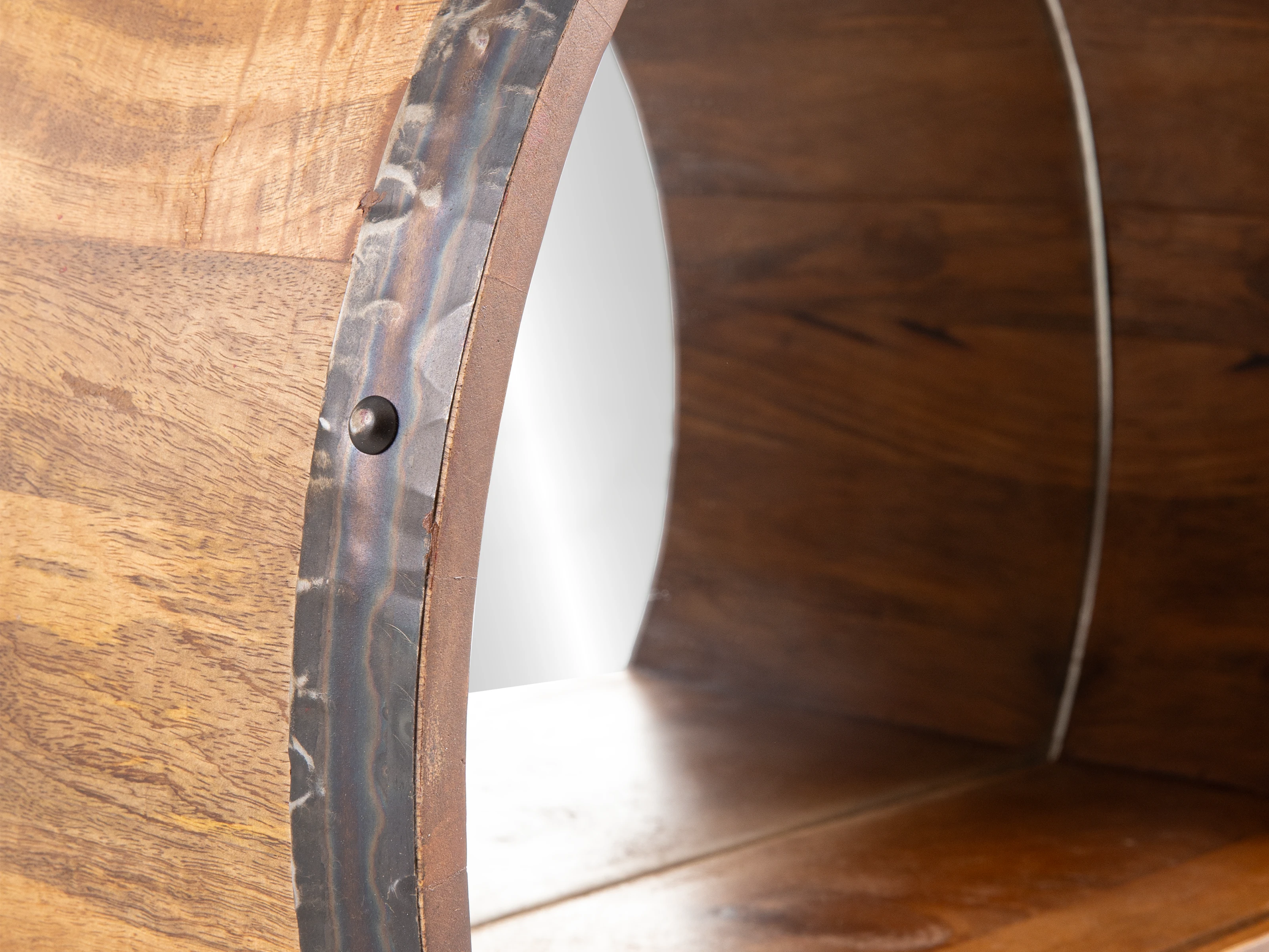 Detailbild des Badspiegel Barrel in 45°-Ansicht: Rundes, lackiertes Holz mit gewelltem Metallrand.