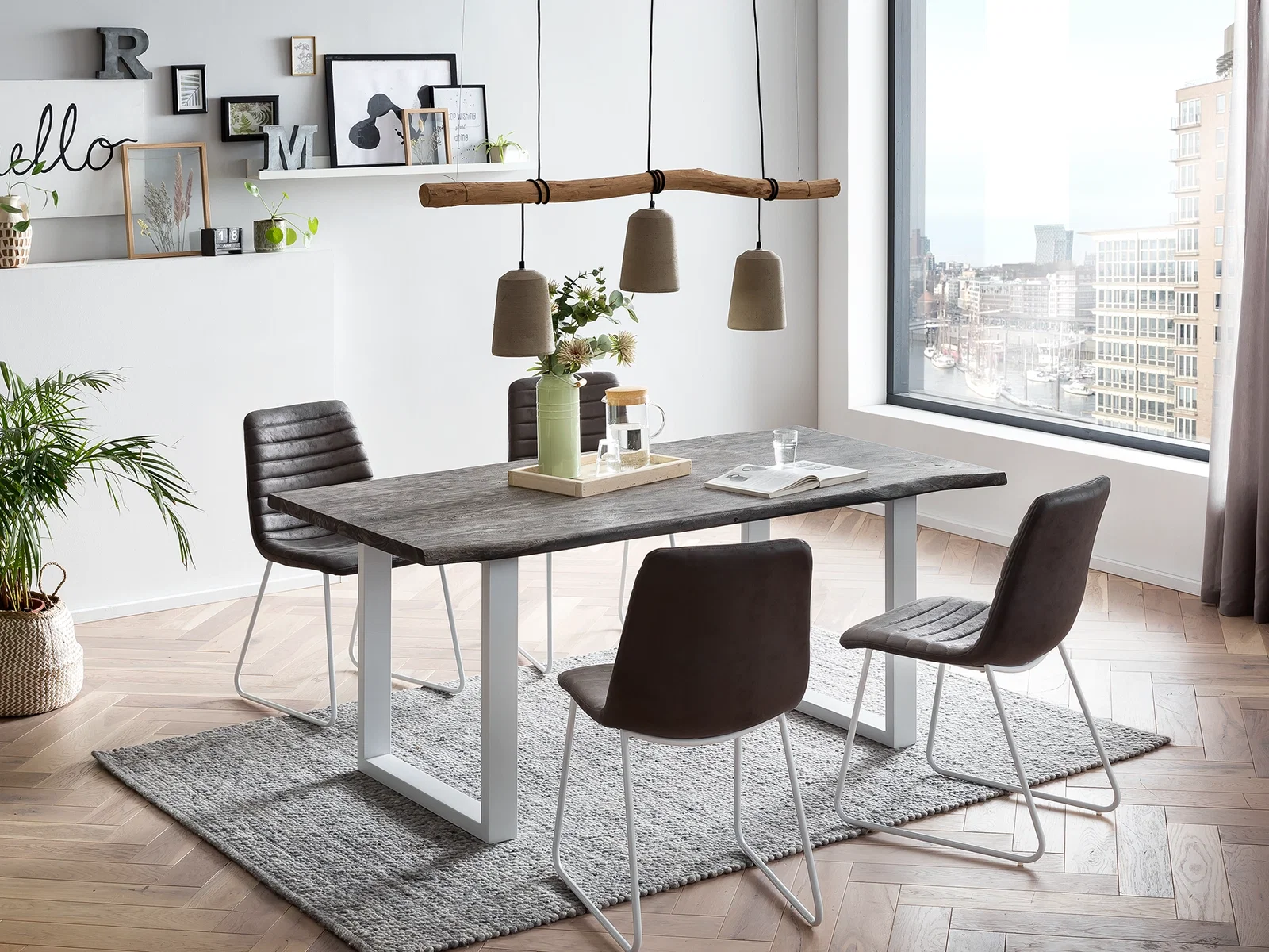 Essgruppe mit dunkler Tischplatte, Metallbeinen und modernen Stühlen als ruhiger Mittelpunkt im hellen Esszimmer