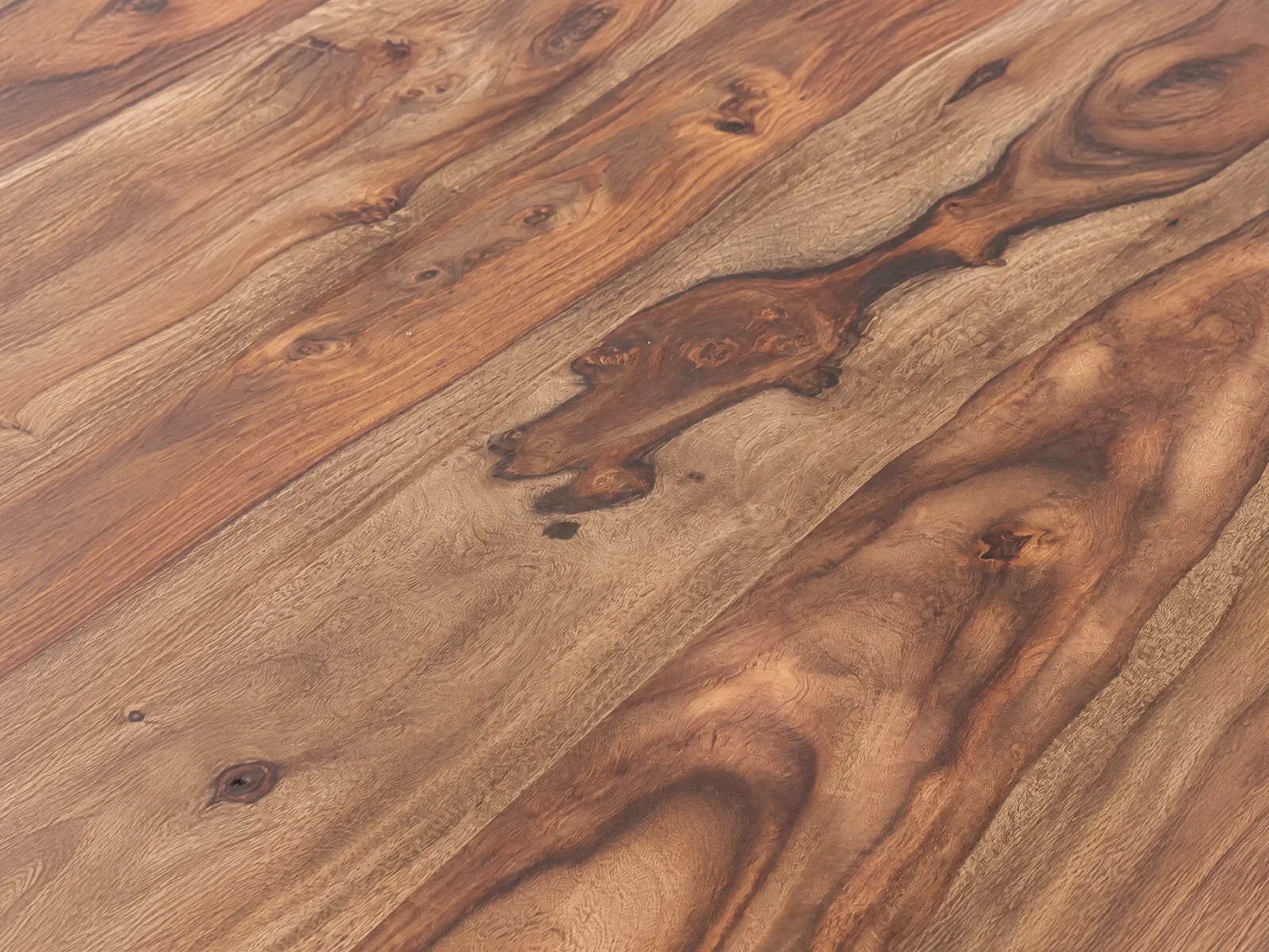 Detailaufnahme einer Palisanderoberfläche mit lebendiger Holzmaserung und natürlichen Farbverläufen