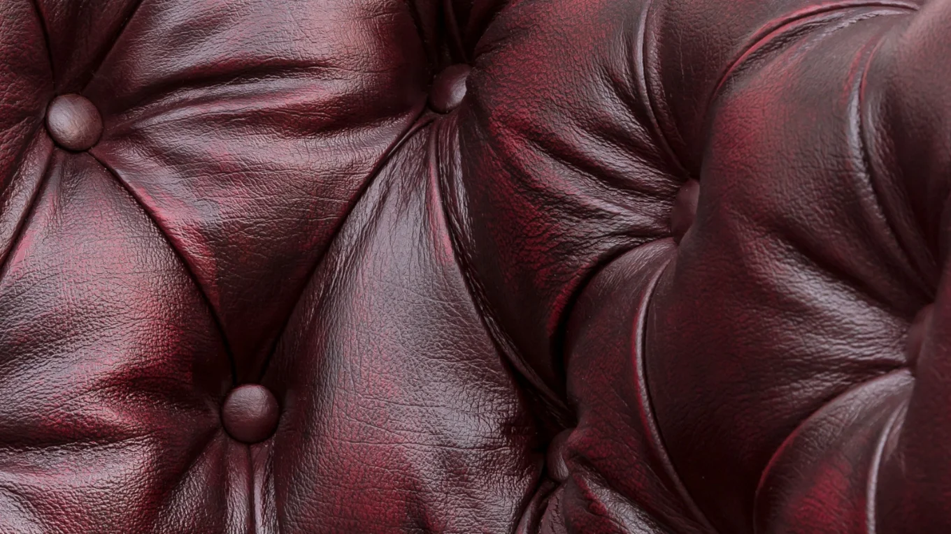 Rotes Leder als Material-Detail in Nahaufnahme, sichtbare Struktur und feine Maserung, gleichmäßige Ausleuchtung, warmer Farbton und glatte Oberfläche