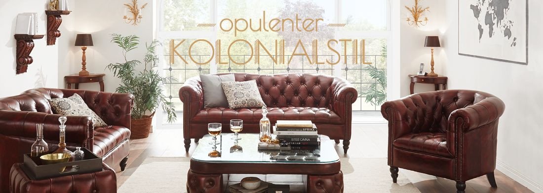 Kolonialstil-Wohnzimmer mit dunklen Holzmöbeln, Sofa, Sessel, Akzenten aus Rattan und Pflanzen, warme Erdtöne und Dekoration