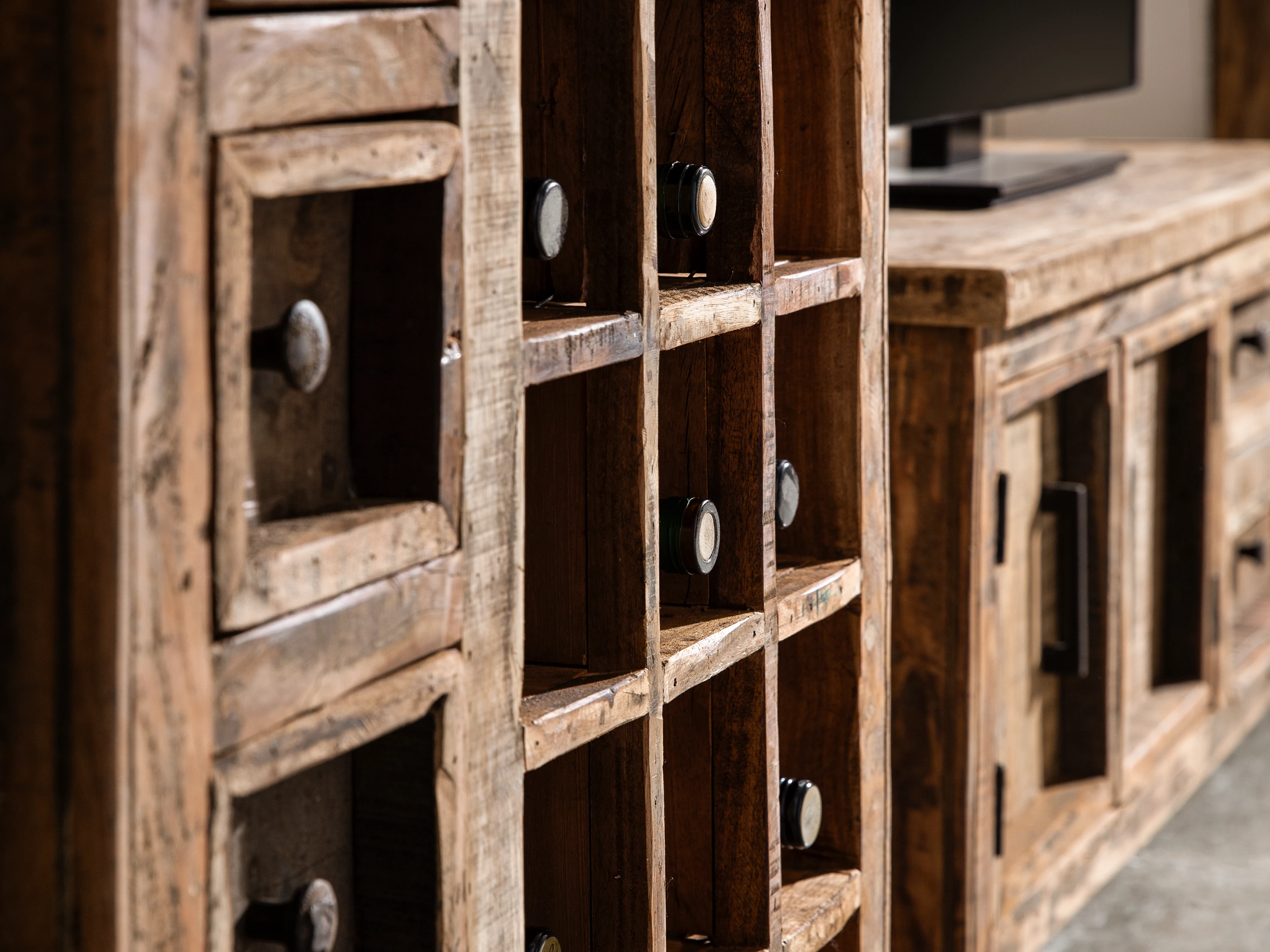 Detailaufnahme eines massiven Holzmöbels in warmem Ambiente, sichtbare Holzmaserung, matte Oberfläche und natürliche Farbtöne