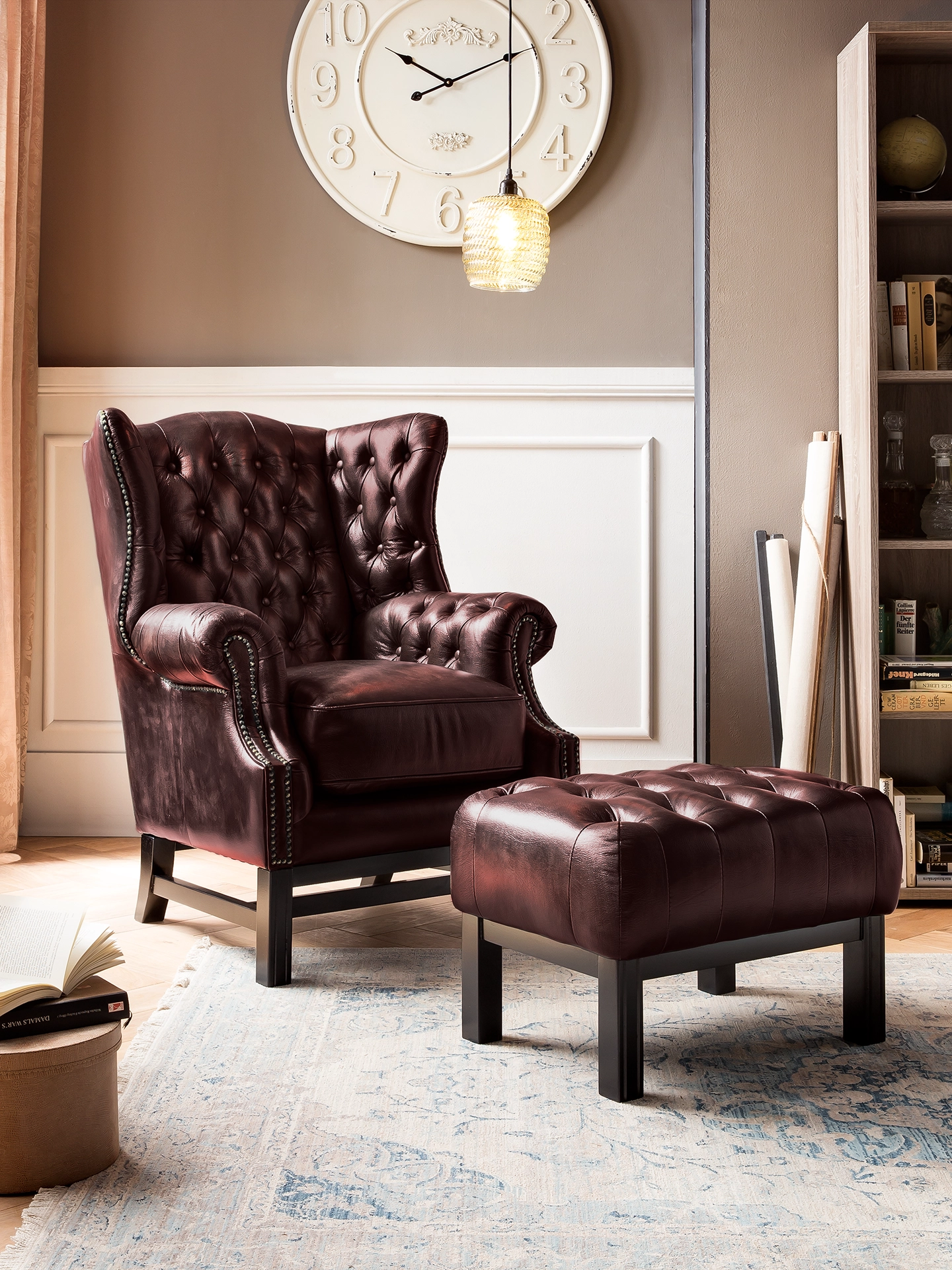 Hoher Chesterfield-Sessel mit tiefgeknöpfter Rückenlehne, braunem Leder und Holzfüßen in gemütlichem, klassischem Ambiente