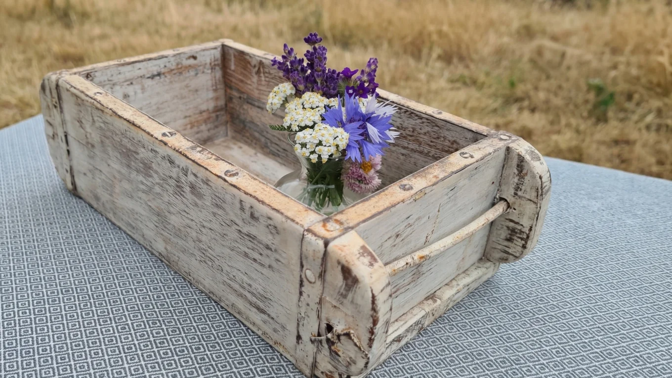Dekorative Ziegelform mit Frühlingsblumen und Osterdeko, rustikales Holztablett im hellen, freundlichen Ambiente