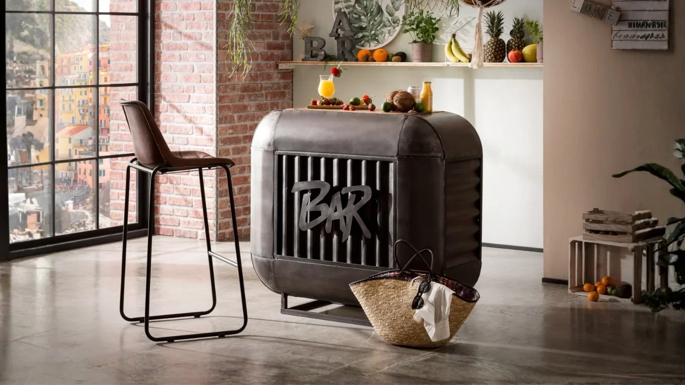 Industrielle Hausbar aus Metall mit BAR-Schriftzug, Barhocker und Loft-Ambiente mit Backsteinwand, Pflanzen und Obst