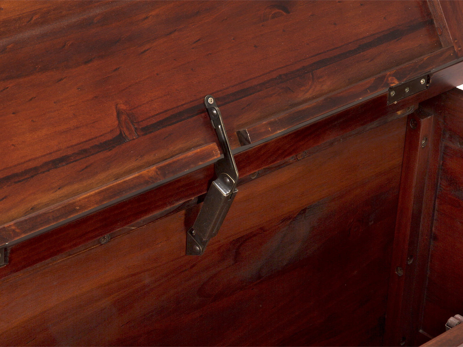 Detailansicht geöffnete Truhe Catana braun – Frontansicht des Gasdruckdämpfers an lackierter Pinie-Holzoberfläche