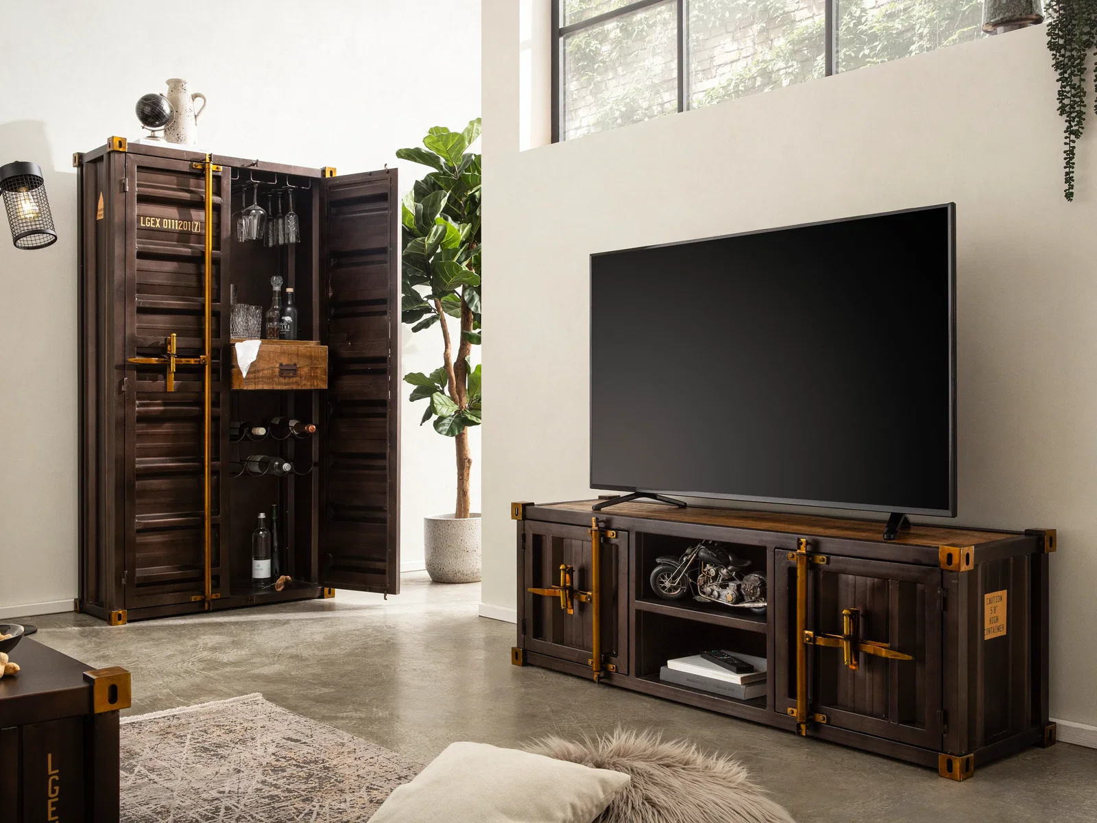 TV-Bank und hoher Schrank der Serie Cargon aus dunklem Metall mit markanten Beschlägen in einem hellen Wohnzimmer