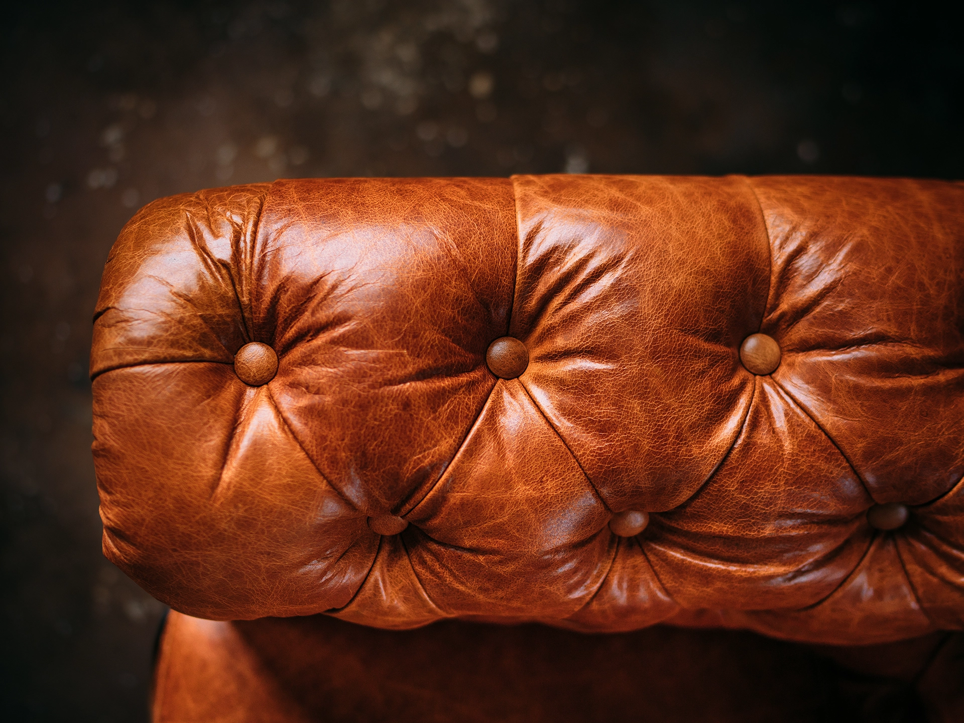 Dunkelbraunes Chesterfield-Ledersofa mit klassischer Knopfheftung, Holzfüßen und edlem Wohnzimmer-Ambiente