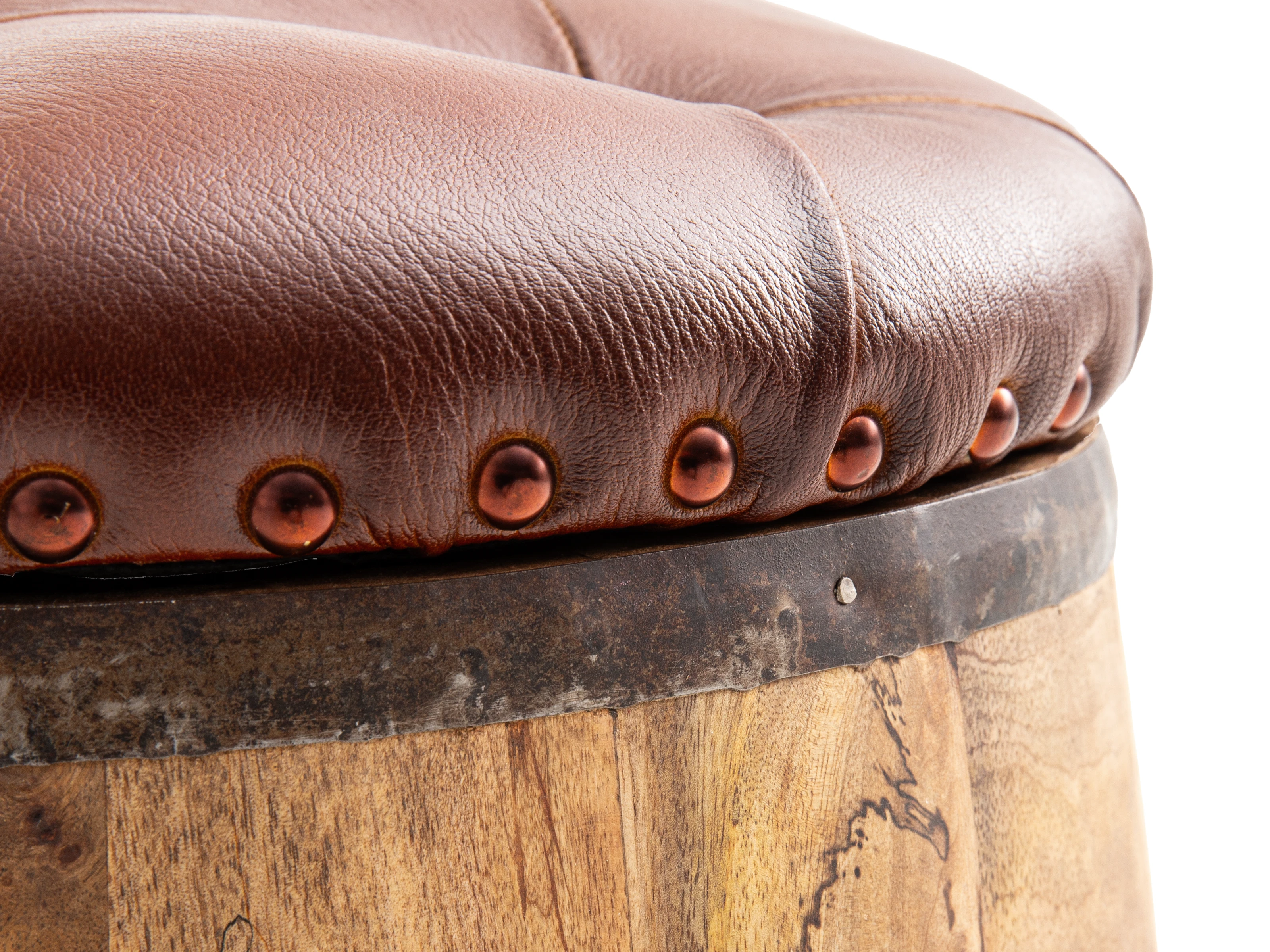 Freisteller-Detail Holzfass Flip: 45°-Ansicht des braunen Lederpolsters mit Kupfernieten auf dem rustikalen Holzfass-Hocker. Freisteller-Detail Holzfass Flip: 45°-Ansicht des braunen Lederpolsters mit Kupfernieten auf dem rustikalen Holzfass-Hocker.