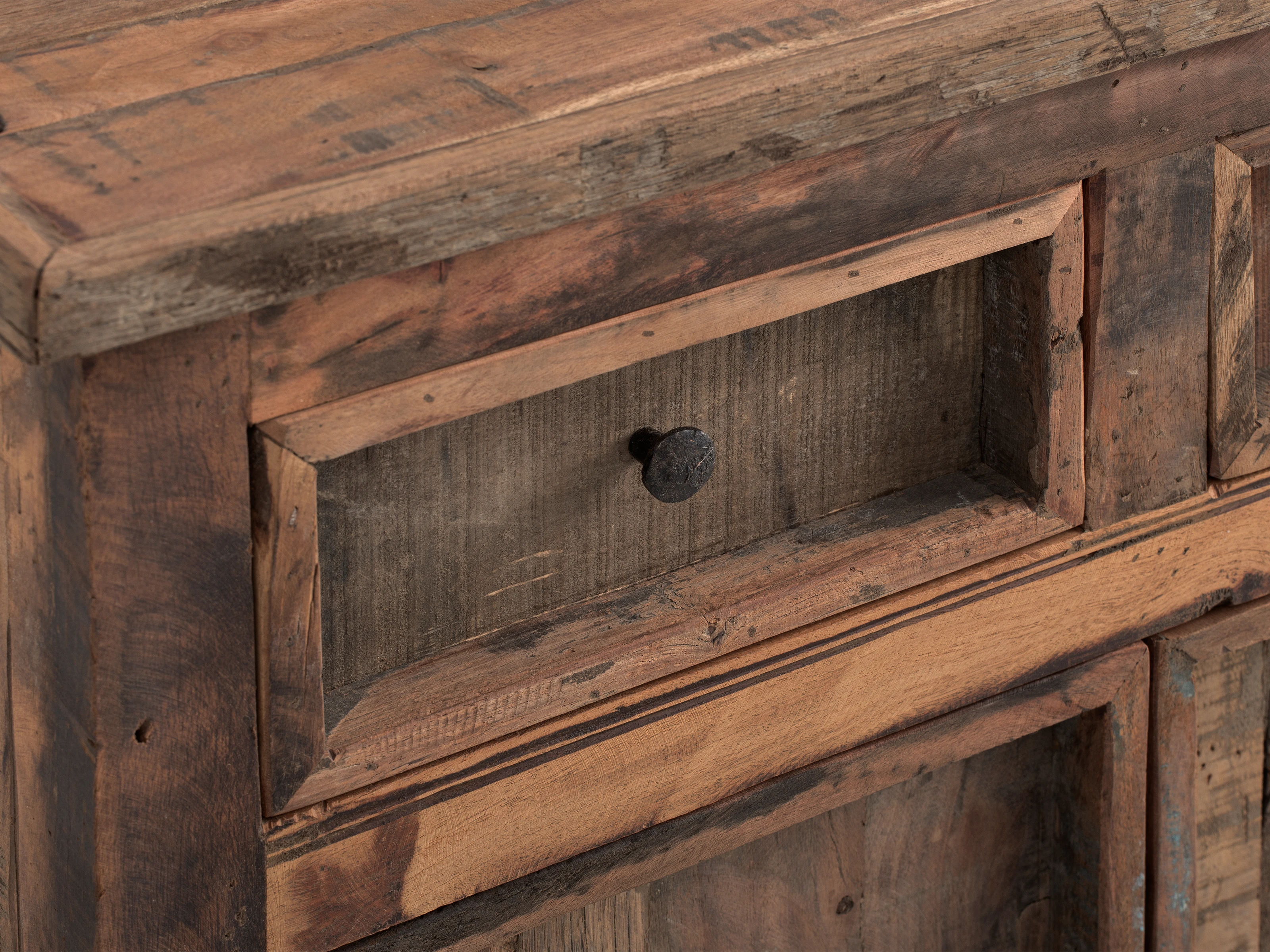 Detailaufnahme geölter Holzoberfläche eines Möbelstücks mit deutlicher Holzmaserung, warmen Naturtönen und feiner Handwerksstruktur.