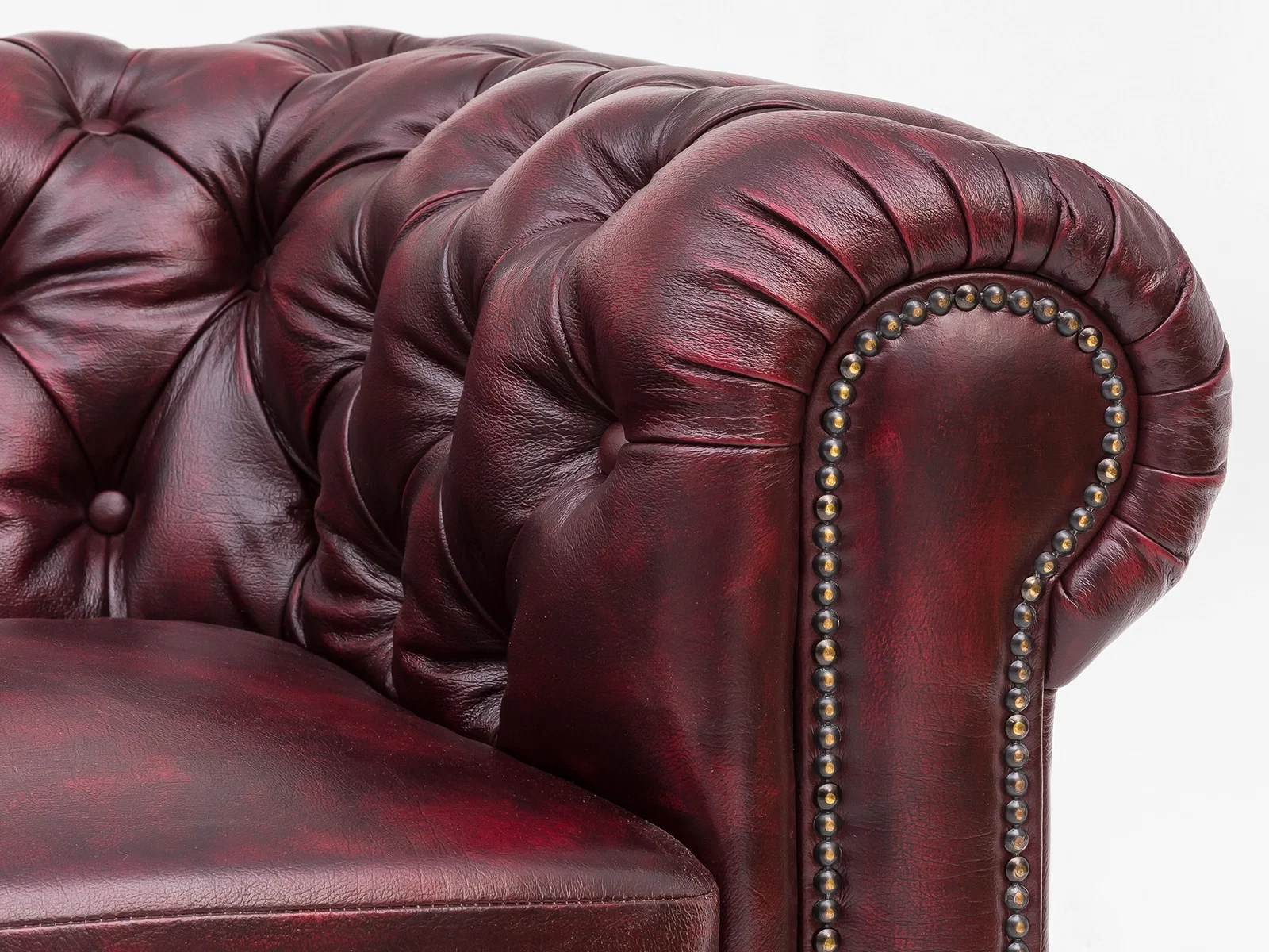 Chesterfield-Detail: tief geknöpfte, genarbte dunkelbraune Lederoberfläche mit Steppnaht – klassisches, edles Sofa-Design