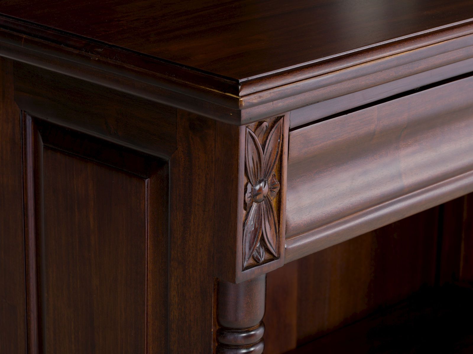 Detailansicht der geschnitzten Seitenleiste des Bücherregals Cambridge II in lackiertem Mahagoni, 45°-Ansicht Detailansicht der geschnitzten Seitenleiste des Bücherregals Cambridge II in lackiertem Mahagoni, 45°-Ansicht