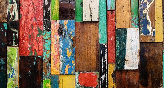Recycelte Holzoberfläche mit sichtbarer Maserung und patinierter, mehrfarbiger Plankenstruktur – rustikales Vintage-Flair für Möbel und Wandverkleidung.